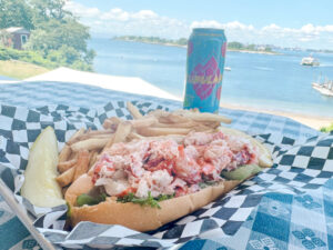 lobster roll and orono brewing co beer at the island lobster co with a view of the ocean in the background