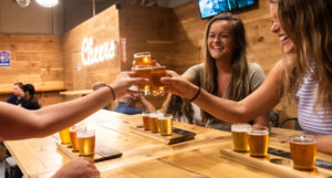 shipyard tasting room people cheersing beer