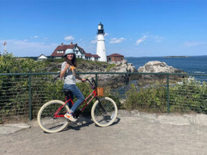 person on bike in front of portland head light