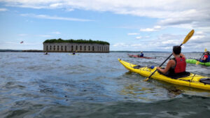 kayaking in the ocean with fort in background