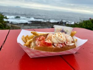 the lobster shack at two lights lobster roll with ocean in background